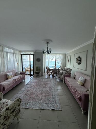 a living room with pink couches and a table at Trabzon Sea Pearl in Trabzon