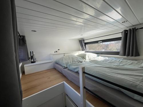a bed in the middle of a room with a window at Tiny House Spreemaus in Hangelsberg