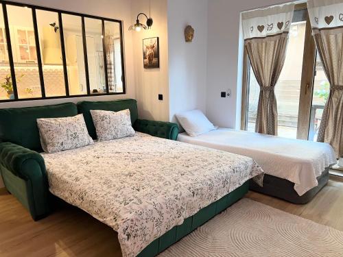 a bedroom with two beds and a green couch at Summer Studio in Constanţa