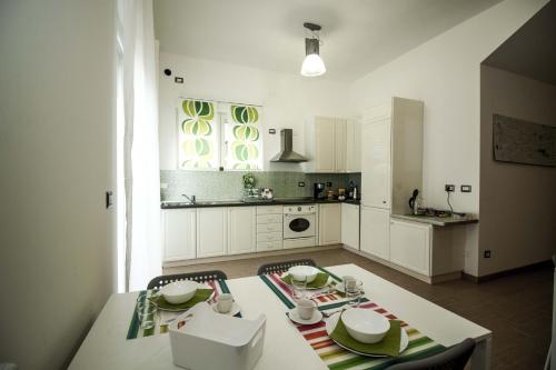 uma cozinha branca com uma mesa e cadeiras em Green Bed Bergamo Guest House & Residence em Bérgamo