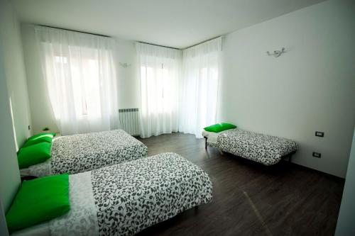 a room with two beds and a bench in it at Green Bed Bergamo Guest House & Residence in Bergamo