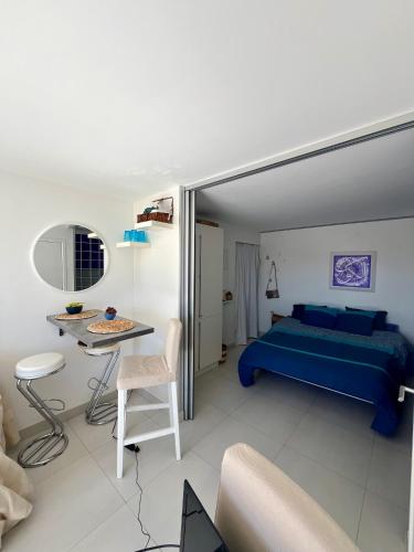 a bedroom with a blue bed and a table at TOUT A PIED Dernier étage Vue imprenable EST-SUD OUEST mer -plage 100m-box in Six-Fours-les-Plages