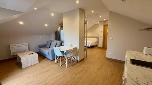 a room with a couch and a table and a bed at Apartamentos La Canal in Soto de la Marina