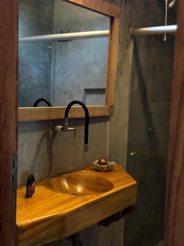 a bathroom sink with a faucet and a mirror at Tamikuã Mar Pousada in Caraíva