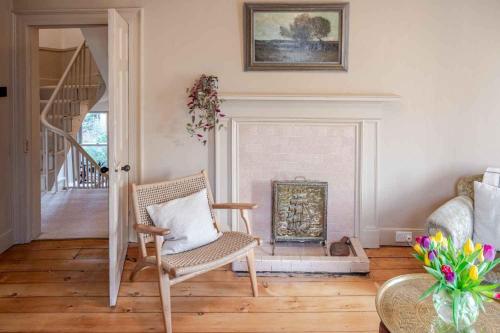 a living room with a chair and a fireplace at Mackenzie House in Kirkcudbright
