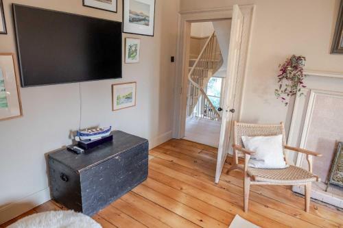 a living room with a flat screen tv on the wall at Mackenzie House in Kirkcudbright