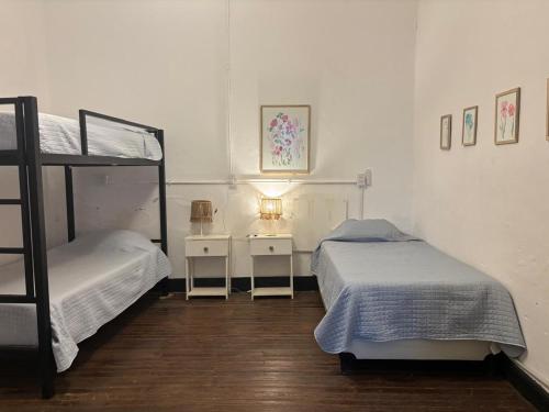 a bedroom with two bunk beds and two tables at Posada Las Chacras in Ciudad Lujan de Cuyo