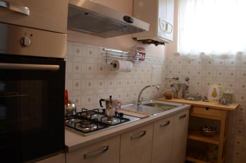 a kitchen with a sink and a stove top oven at Theia Apartment in Chianciano Terme