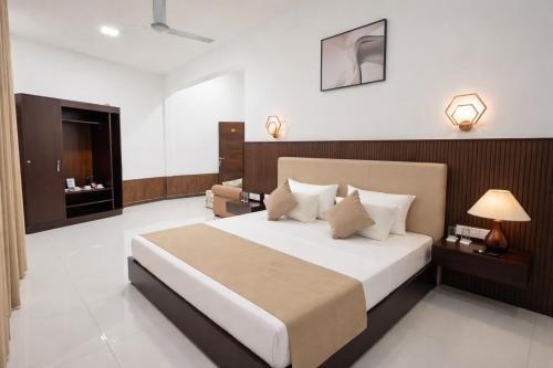 a bedroom with a large bed and a television at Yaazoraa Anuradhapura in Maha Kalattewa