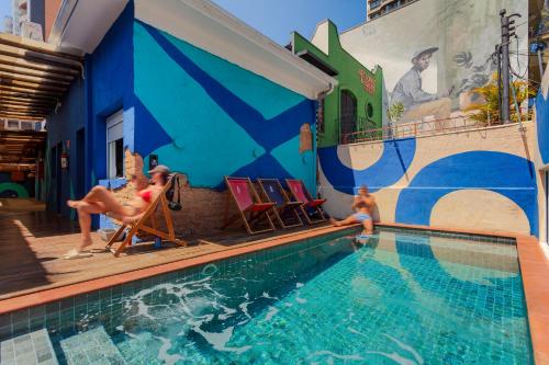 a swimming pool with people playing in the water at Ô de Casa Hostel Bar in São Paulo
