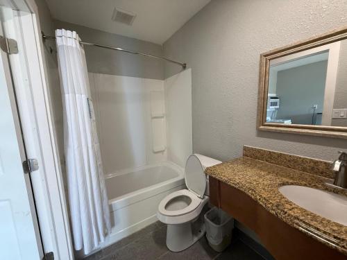 a bathroom with a toilet and a sink and a shower at Bel-Air Motel in Alice