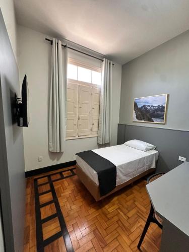 a small bedroom with a bed and a window at B Hotel 888 hotéis - Próximo a Rodoviária e Praça Sete in Belo Horizonte