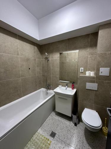 a bathroom with a toilet and a tub and a sink at Travel Studio in Iaşi