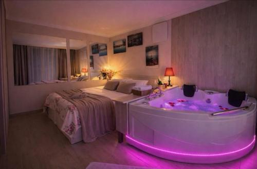 ein Hotelzimmer mit Badewanne und Bett in der Unterkunft Ramgon in Gonio