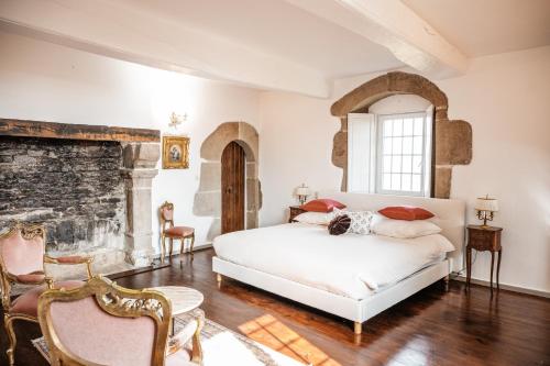 a bedroom with a bed and a stone wall at Manoir La Ville Durand in Binic