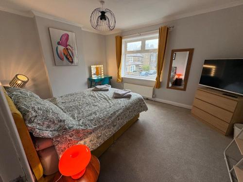 a bedroom with a bed and a flat screen tv at Bright Harrogate flat 2 beds great location in Harrogate