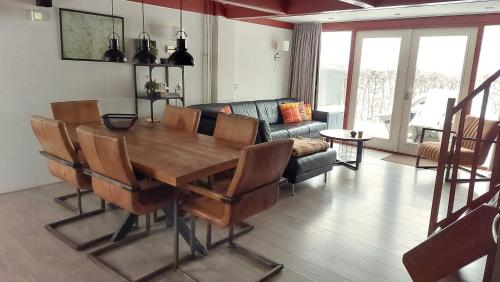 a living room with a wooden table and chairs at Vakantiehuis Toermalijn in Simpelveld