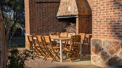 a table and chairs in front of a brick building at Chalet en La Rioja para familias y grupos in Tricio