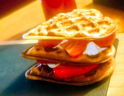 two waffles with cheese and fruit on a plate at Esca with Rooms in Ross on Wye