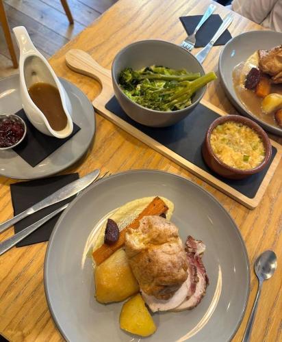 a table with a plate of food and a tray of food at Esca with Rooms in Ross on Wye