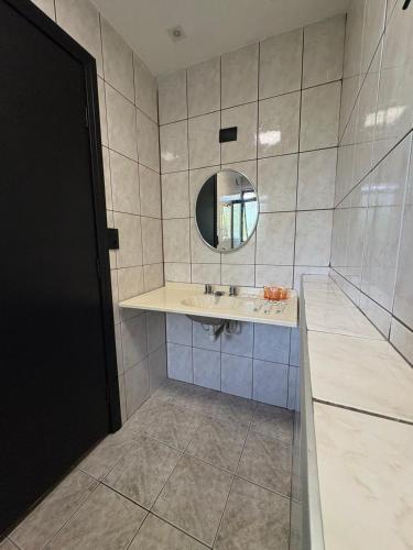 a bathroom with a sink and a mirror at Travessa 12 - Suítes centro de Serra Negra - SP in Serra Negra