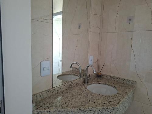 a bathroom with two sinks and a mirror at Hotel Pampa in Nova Santa Medianeira