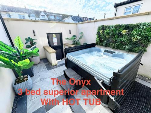 an outdoor hot tub on a patio with plants at Swish Luxury Holiday Apartments 2 in Blackpool