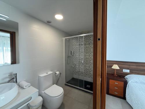 a bathroom with a toilet and a sink and a shower at Living one Bed and Breakfast in Peniscola