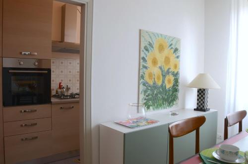 a kitchen with a table and a painting on the wall at Theia Apartment in Chianciano Terme