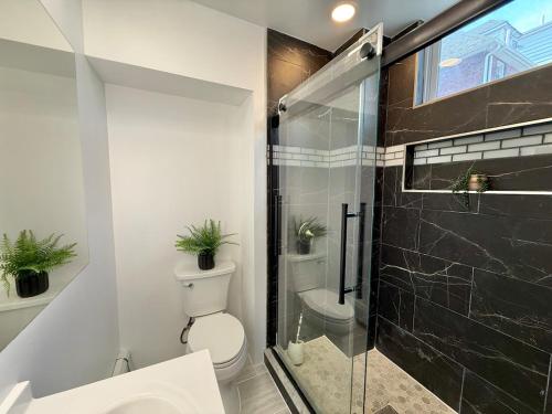 a bathroom with a toilet and a glass shower at Modern apartment close to NYC in North Bergen