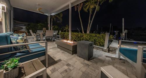 a patio with a fireplace and a swimming pool at night at Villa Azule-Waterfront-Dock-Free Amenities-Bikes-Fishing and Beach Gear in Clearwater Beach