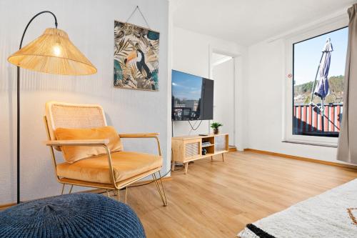 a living room with a chair and a television at Tucan - Rooftop Terrace with View, BBQ, PS4+Stream in Marburg an der Lahn