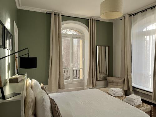 a bedroom with a large bed and a window at La Poterne l Chambres d'hôtes à Epernay in Épernay