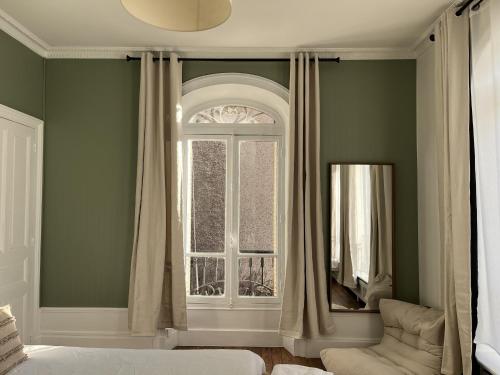a living room with a window and a chair at La Poterne l Chambres d'hôtes à Epernay in Épernay