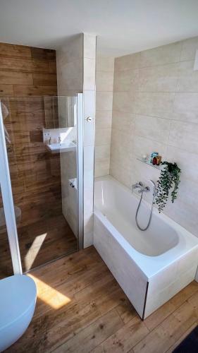 a white bathroom with a tub and a toilet at Penthouse Seebrise in Großräschen