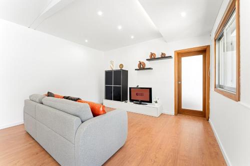 a living room with a couch and a television at GuestReady - Charming beachside retreat in Mindelo