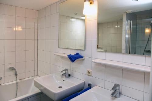 a white bathroom with a sink and a mirror at Woonboot Sweltsje in Earnewâld