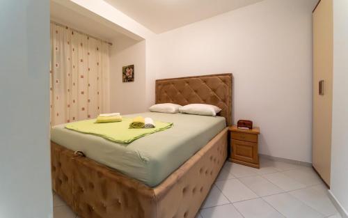 a bedroom with a large bed with a wooden headboard at Olive View apartment in Rafailovici
