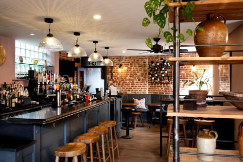 a bar with wooden stools and a brick wall at The Mistley Thorn in Mistley