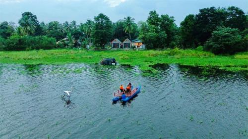 a group of people in a small boat in the water at Sunrise Lake Resort in Polonnaruwa