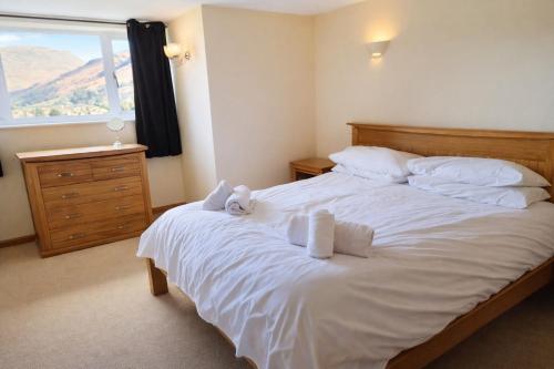 a bedroom with a large white bed with towels on it at Grasmere View, stunning views over Grasmere Lake, ideal romantic break in Grasmere
