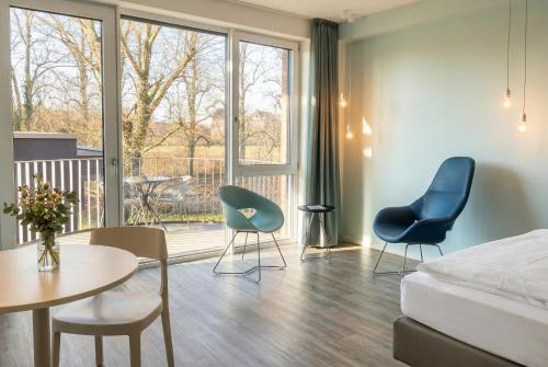a hotel room with a bed and chairs and a table at Steverbett Hotel in Lüdinghausen