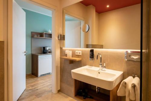a bathroom with a sink and a mirror at Steverbett Hotel in Lüdinghausen
