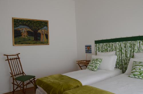 a bedroom with two beds and a painting on the wall at Theia Apartment in Chianciano Terme