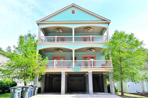a large house with a balcony on top of it at The Palm Luxury Beach House w Pool and Game Room in Myrtle Beach