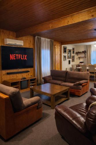 a living room with leather couches and a television at Cabana Brazilor in Câmpina