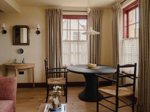 a living room with a table and chairs and a window at Luxury Apartment with Roof Terrace - Cotswolds in Stow on the Wold