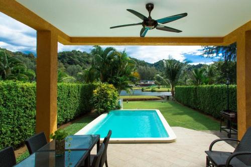 a patio with a swimming pool and a ceiling fan at Royal Shell by Utalay Koh Chang in Ban Khlong Son
