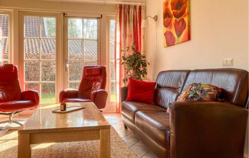 a living room with a leather couch and two chairs at Buitengoed Het Lageveld - 65 in Hoge-Hexel