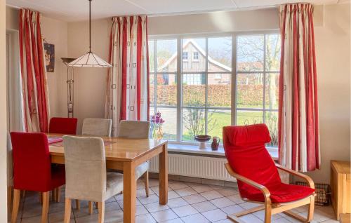 a dining room with a table and chairs and a window at Buitengoed Het Lageveld - 65 in Hoge-Hexel